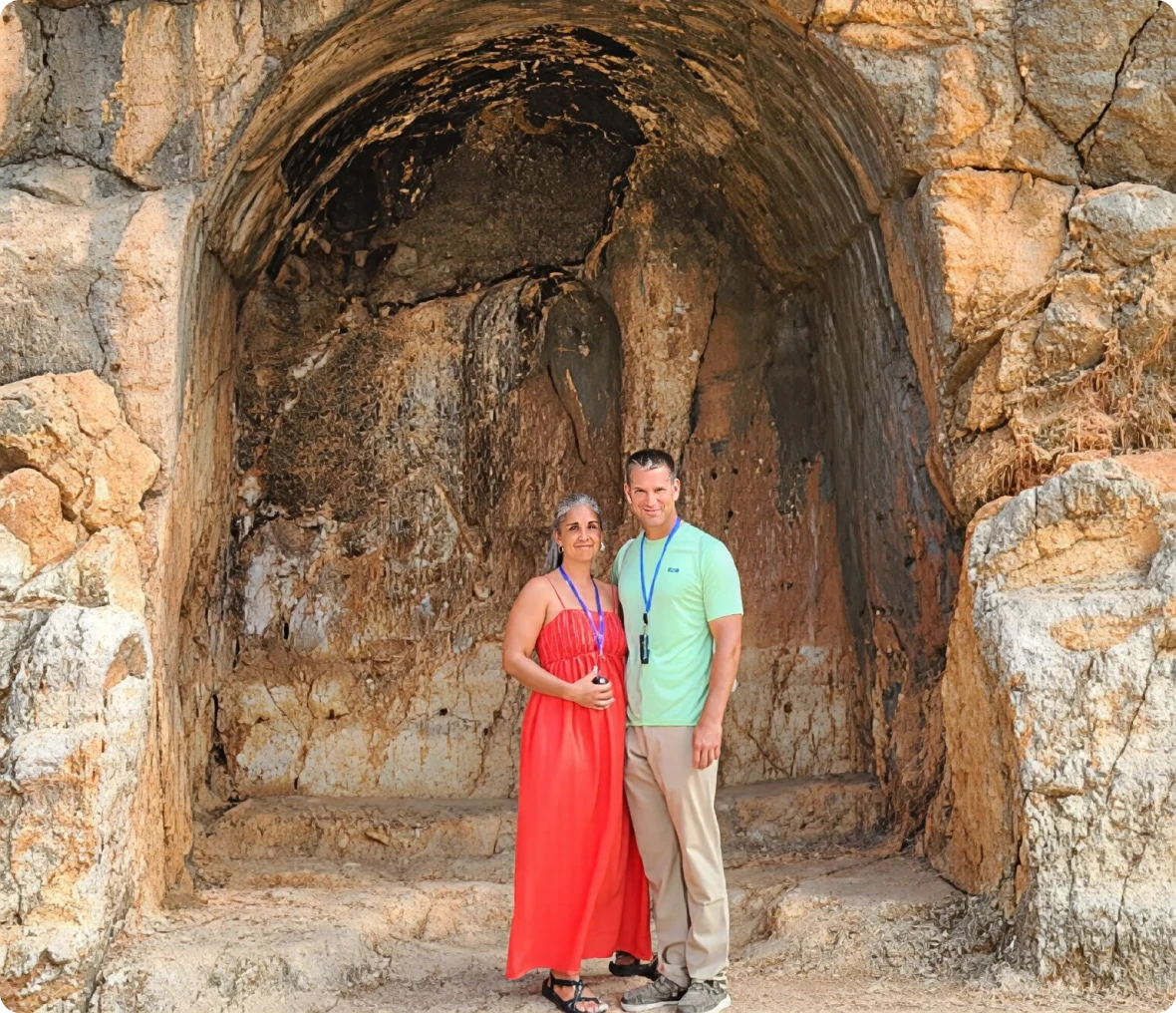 Visitors standing in stone cave entrance