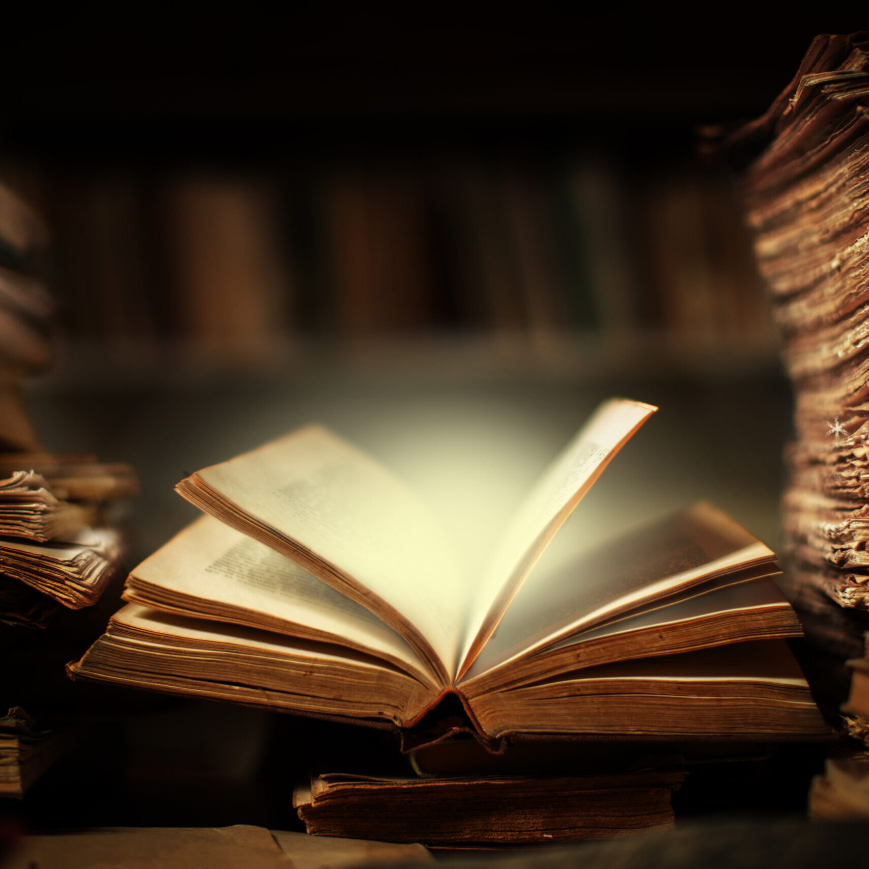 Illuminated book pages surrounded by documents